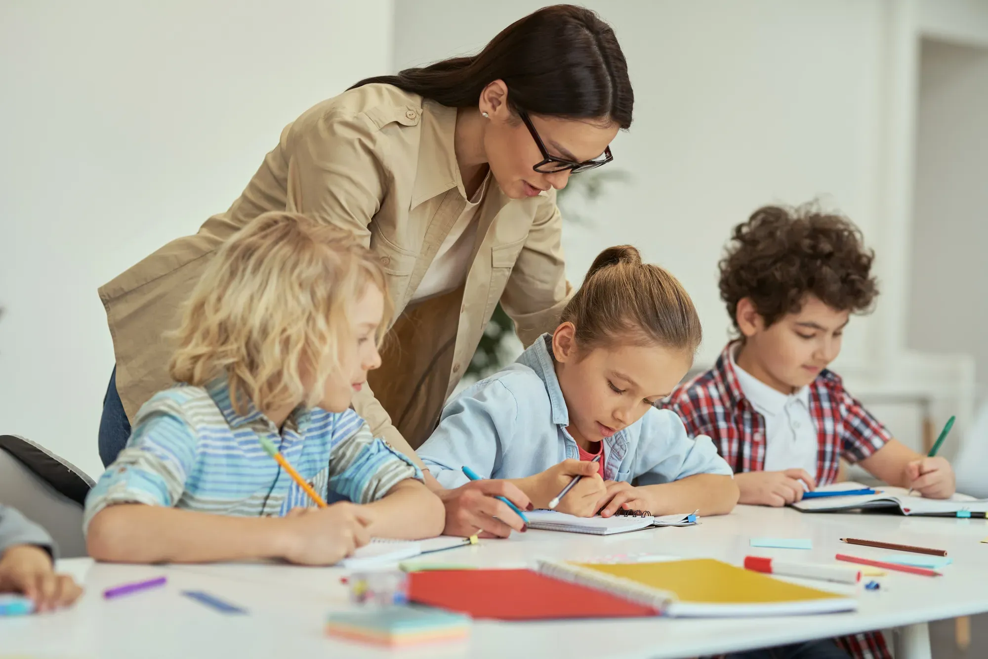 Kinder arbeiten gemeinsam mit einer Lehrerin